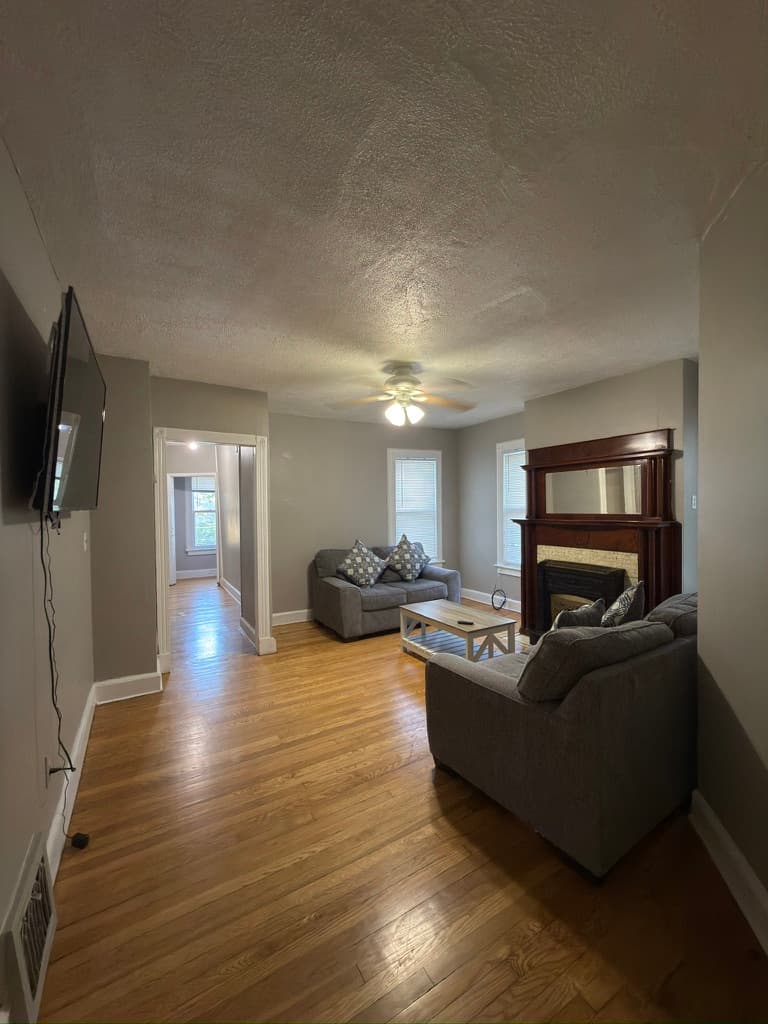 33 St. John Avenue — Living room 1 with sofas, coffee table, and wood mantel